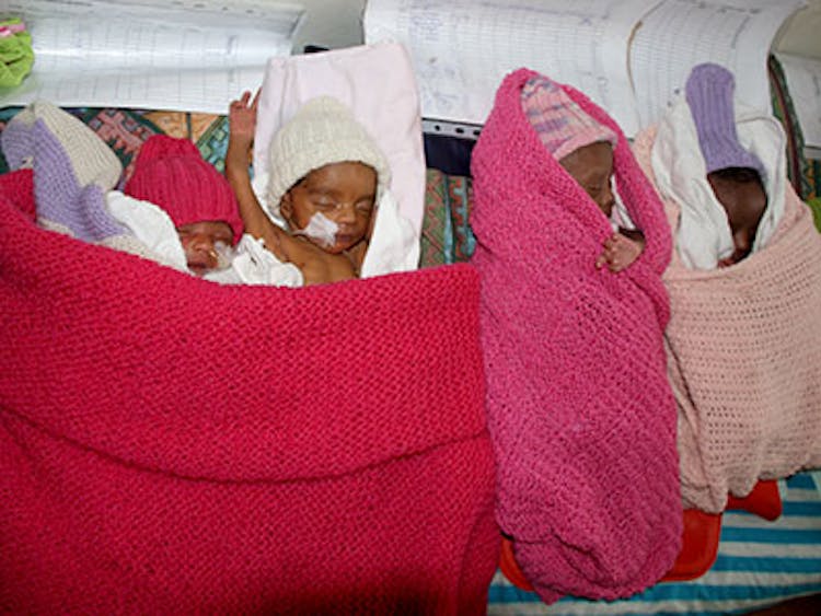 flere nyfødte babyer pakket inn i strikkede pledd
