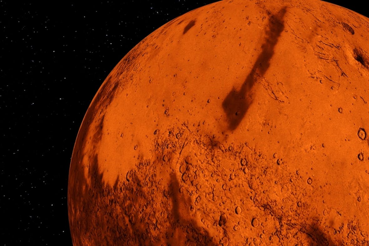 Den røde planeten Mars med lysende stjerner i bakgrunnen