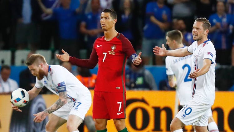 Christiano Ronaldo står på banen i rød drakt og ser oppgitt ut