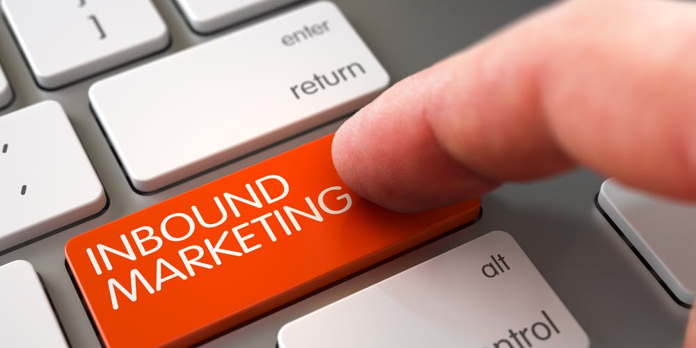 Finger trykker på et tastatur på en oransje knapp hvor det står "Inbound marketing"