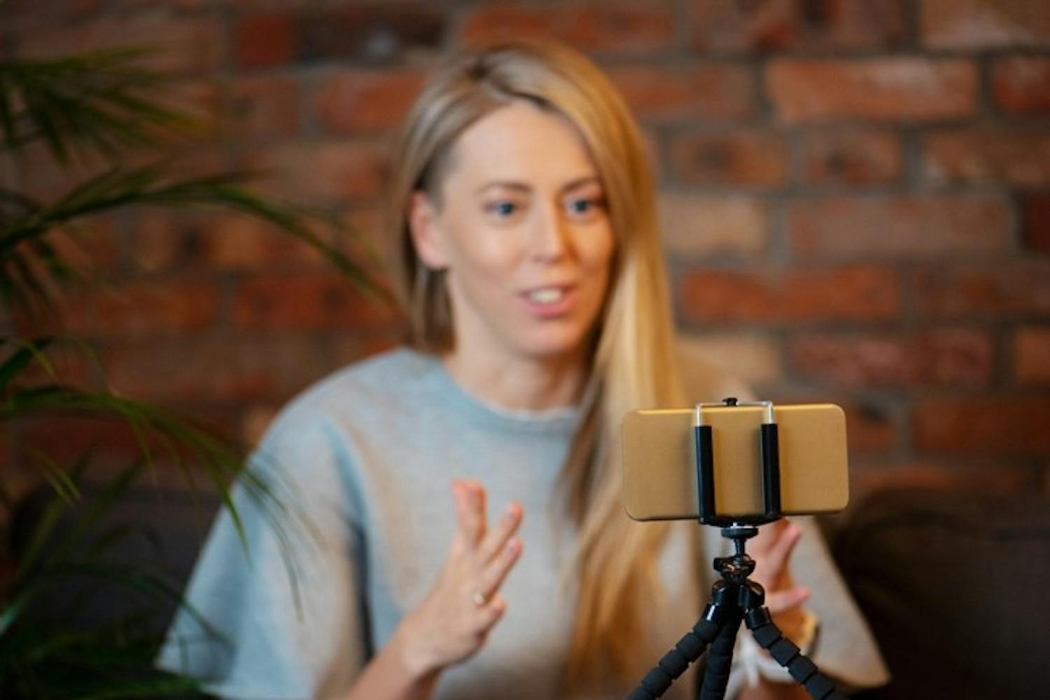 Foto av kvinne som filmer video av seg selv med en smarttelefon