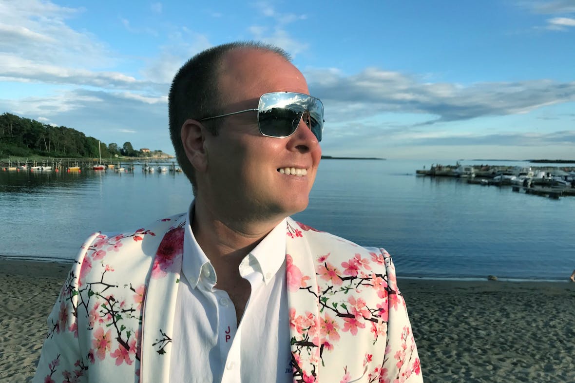 Daglig leder i Iteo, Andreas Thue, smiler i fargerik dress på en sommerdag.