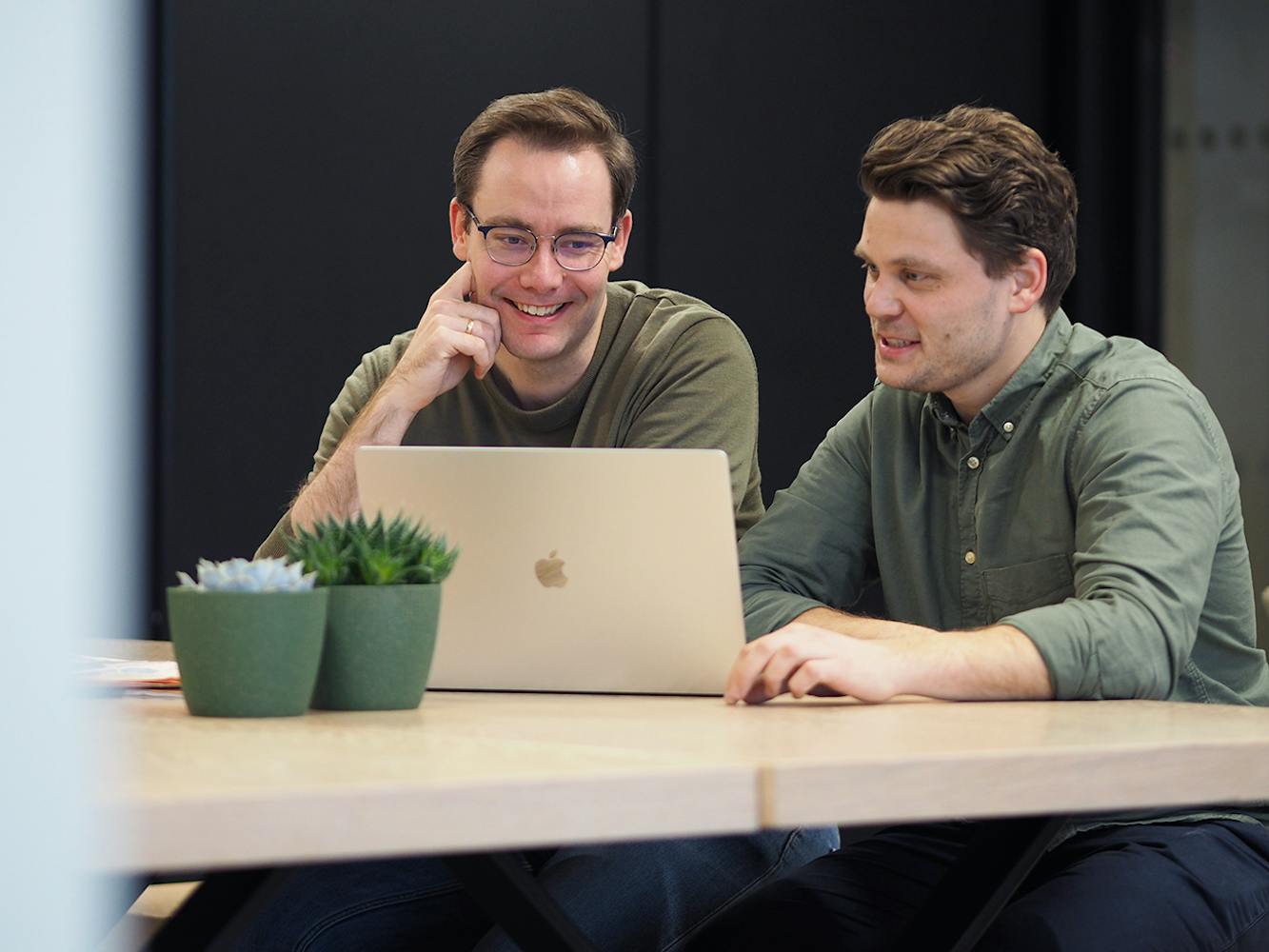 Stein Arne og Hans-Petter ser på en Mac og snakker seg imellom om tips til bedrfiter som vil markedsføre egne verdier på en positiv måte.