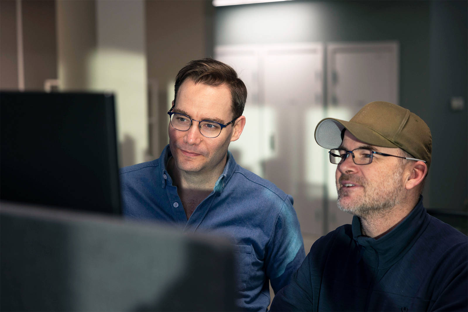 Stein Arne Gausen og SImen Berg ser positive resultater på en dataskjerm og smiler smått, når de bruker Min merkevaremåler for en kunde.