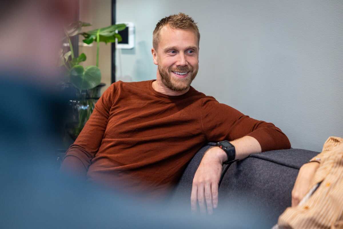 Iteos Alexander smiler til kollega på kontoret