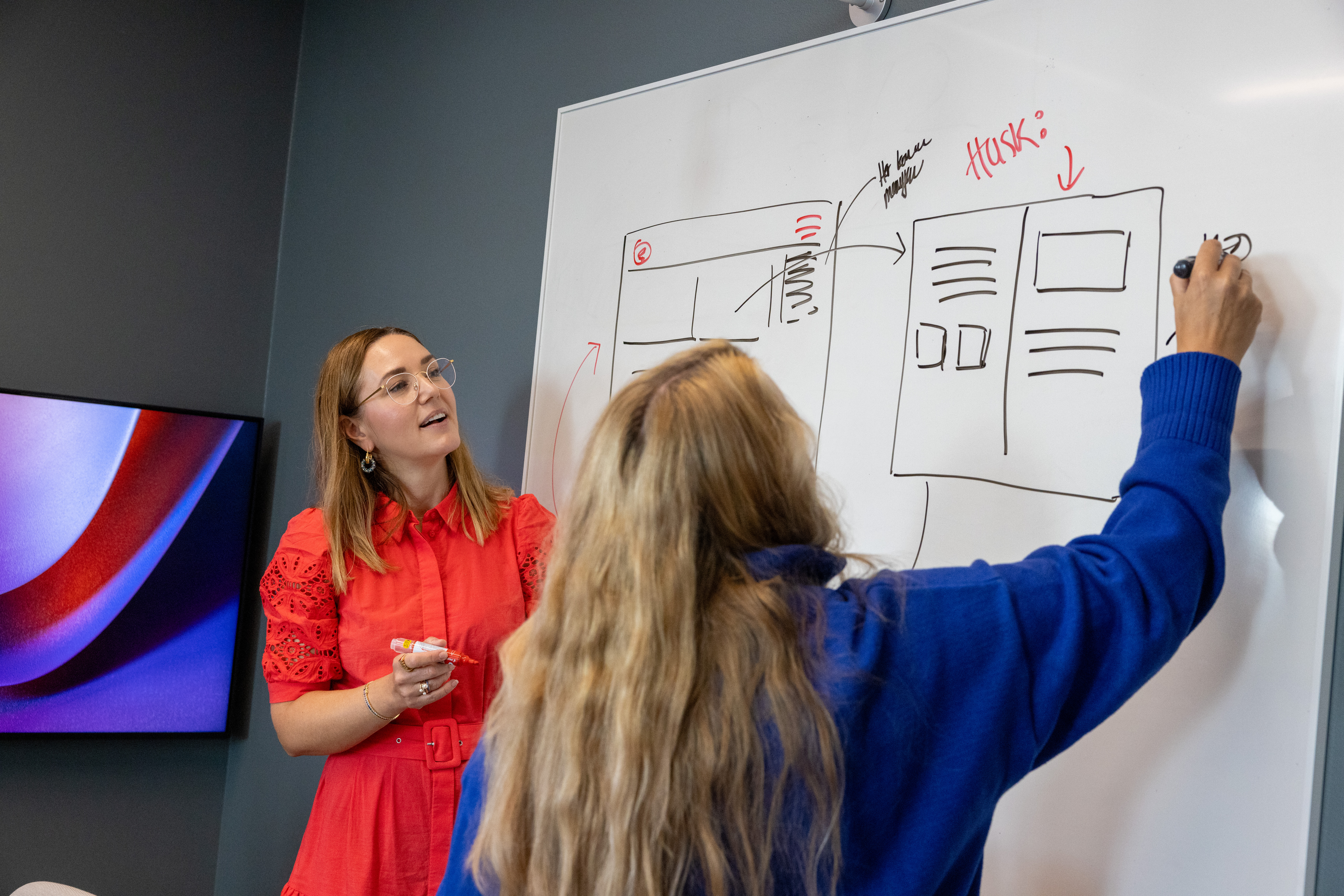 Iteos designere Hanne og Lena drodler på whiteboard